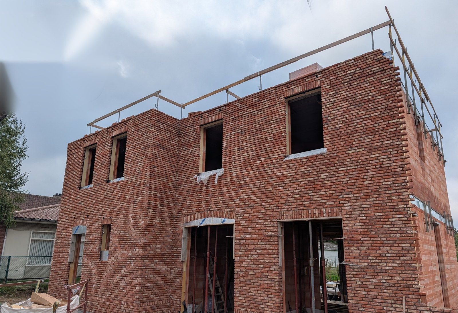 Onze eigen werf: het metselwerk van de verdieping is af, de kraan staat nog naast het huis.